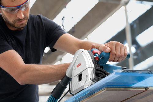 Scie Bosch GKT13-255 utilisée par une personne portant des lunettes de sécurité.