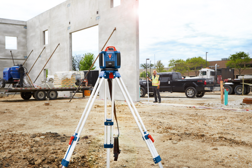 Voici la traduction :

Laser ligne Bosch Professional sur trépied, ouvrier du bâtiment portant un gilet de sécurité et structure en béton sur un chantier.