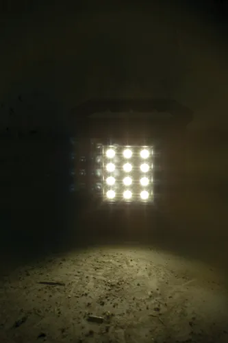 Panneau lumineux avec neuf points lumineux brillants éclairant une surface rugueuse.