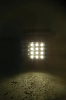 Panneau lumineux avec neuf points lumineux brillants éclairant une surface rugueuse.