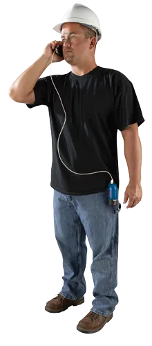 Homme portant des lunettes de sécurité et un casque de protection, parlant au téléphone connecté par un câble à une batterie d'outil Bosch 12V bleue et noire.