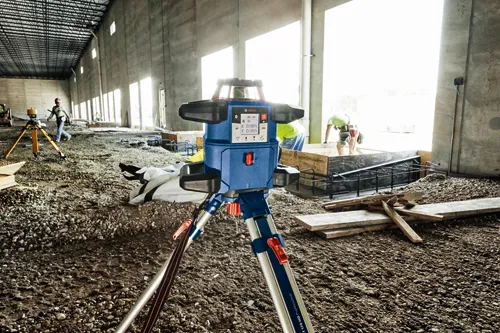 Niveau Bosch, avec affichage numérique des valeurs des axes X et Y, sur trépied, sur un chantier de construction.