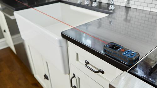 Appareil de mesure laser Bosch Professional, avec pointage laser sur un plan de travail.