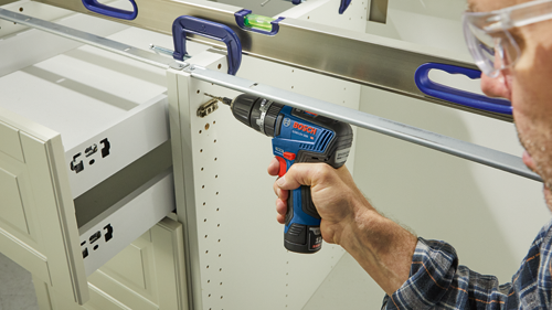 Bosch GSB12V-300 HD perceuse sans fil utilisée pour l'installation de quincaillerie d'armoires.