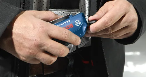 Voici la traduction :

Mains tenant un outil Bosch GAA12V-2 bleu, avec le logo Bosch.