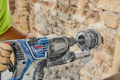Voici la traduction :

Perforateur Bosch BULLDOG GBH18V-28DC utilisé sur un mur en briques.