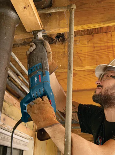 Scie alternative Bosch RS225 utilisée par une personne pour couper du bois.