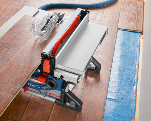 Scie à table Bosch avec lame de scie, détails bleus et rouges, coupant une planche de bois.