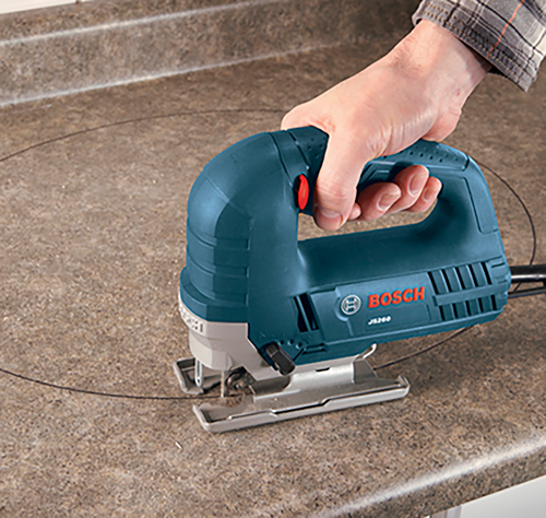 Scie sauteuse Bosch JS260 coupant un cercle sur une surface.