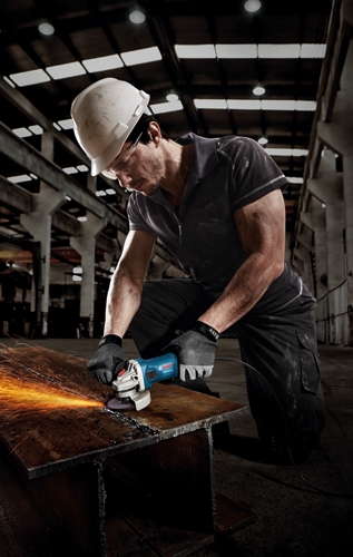 Une personne portant un casque blanc, des lunettes et des gants utilise une meuleuse d'angle Bosch GW59-45 pour couper une poutre métallique, produisant des étincelles.