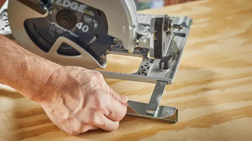 Homme utilisant le guide de la semelle de la scie circulaire sans fil Bosch.