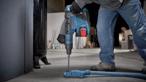 Bosch GBH18V-40C, marteau perforateur BITURBO BRUSHLESS en fonctionnement, personne portant un jean, des gants noirs.