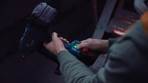 Voici la traduction :

Personne tenant un outil Bosch GNB18V-12 ; voyant LED vert et indicateur de batterie allumés.