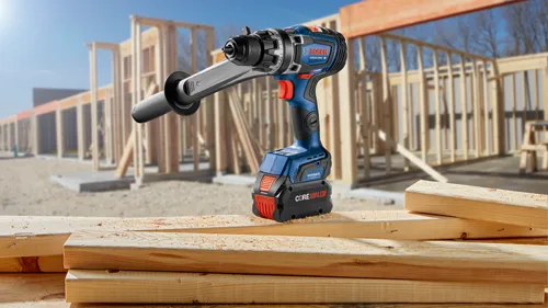 Bosch GSR18V-1330C TURBO perceuse sans fil avec batterie CORE18V 8 Ah et contrôle de rebond, montée sur un chantier avec des poutres en bois.