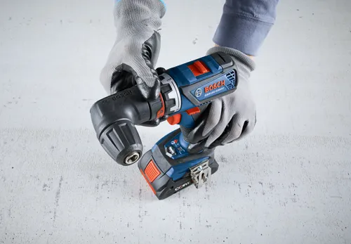Perceuse Bosch GSR18V-535FC, CORE18V. Mains gantées tenant l'outil.