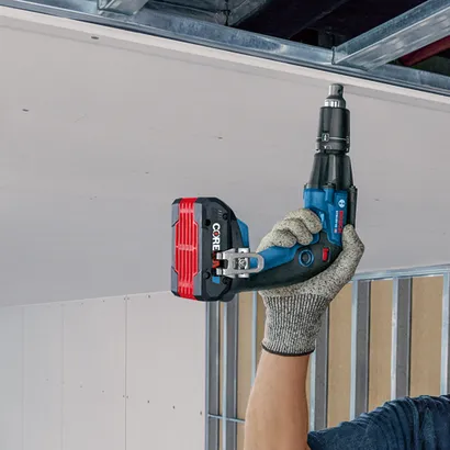 Bosch GTB18V-45 professional visseuse pour plaques de plâtre tenue par une personne portant un gant de protection.