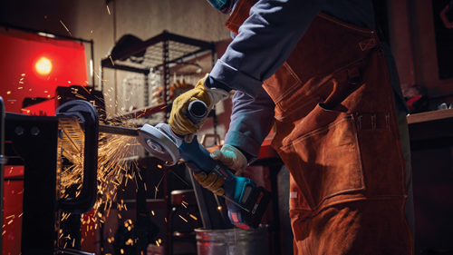 Voici la traduction :

Personne portant un équipement de protection individuelle utilisant une meuleuse d'angle Bosch GW518V-10P, étincelles.