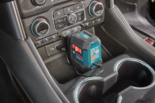 Niveau laser vert Bosch Professional GLL50-20G dans la console de la voiture, branché sur le port USB.