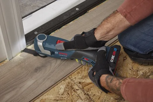 Bosch GOP18V-34 HD outil multifonction oscillant, avec batterie CORE18V 4 Ah, utilisé sur un plancher en bois.