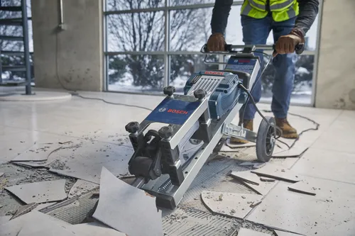 Voici la traduction :

Raclette de sol Bosch utilisée par une personne portant un gilet de sécurité et des gants.