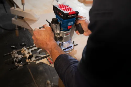 Fraiseuse défonceuse Bosch Colt utilisée pour couper du bois.