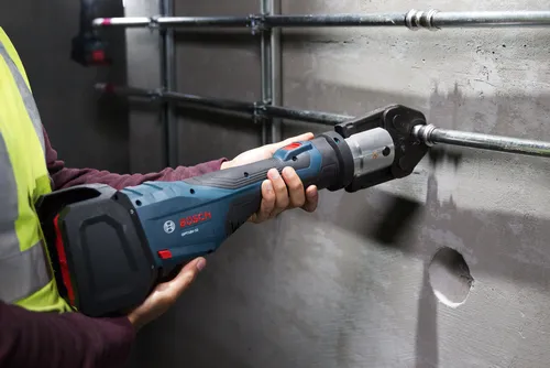 Outil Bosch GPT18V-32 tenu par une personne, sertissant un tuyau métallique.