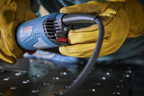 O texto traduzido é:

Outil Bosch tenu par des mains gantées, montrant le logo "BOSCH" et un cadran réglé sur "6".