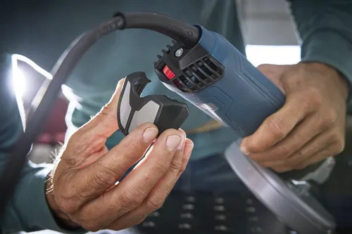 Outil électrique Bosch avec cordon d'alimentation, tenu par une personne. Texte "Bosch" sur le cordon d'alimentation.