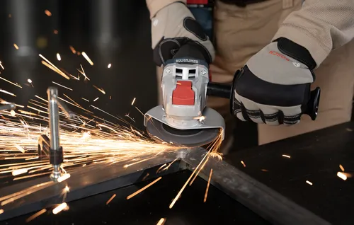 A worker using Bosch GWX18V-8-2 18V X-LOCK Brushless 4-1/2 In. Angle Grinder with Slide Switch for grinding a metal edge.