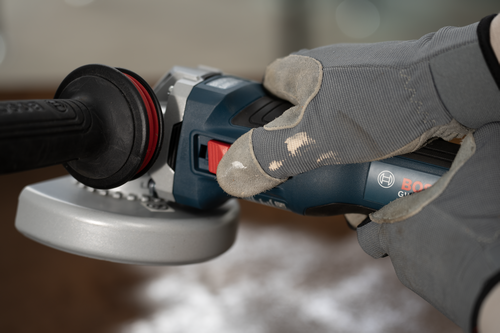 Close-up image of worker holding the Bosch GWS18V-11S 18V Brushless 4-1/2 – 5 In. Angle Grinder with Slide Switch.