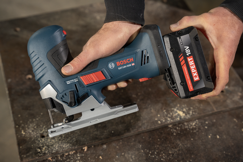 A worker attaching a Bosch EXBA18V-60 EXPERT 18V 6 Ah High Power Battery to a GST18V-50B 18V barrel-grip jig saw.