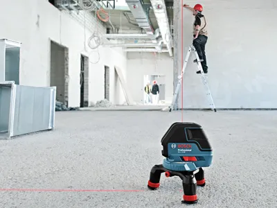 Laser trois lignes Bosch avec faisceau de mise en place GLL3-50 sur chantier.