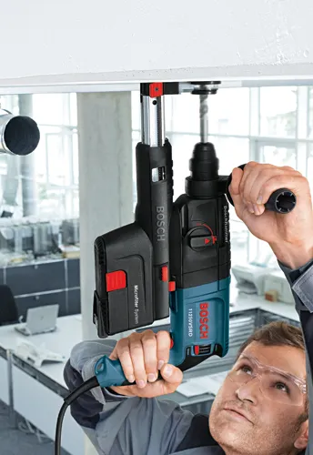 Perfeito. Aqui está a tradução:

Perceuse à percussion Bosch 11250VSRD avec "Microfilter System", utilisée par une personne portant des lunettes de sécurité.