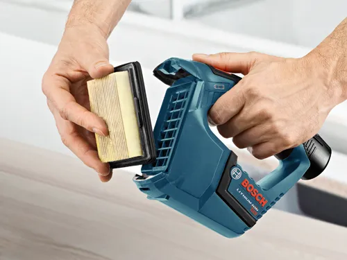 Hands hold a Bosch LITHIUM-ION 12V tool, and a replacement filter is being held.