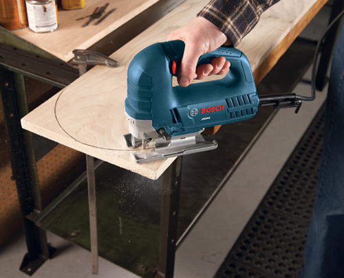 Bosch JS260 jigsaw being used to cut a wooden board.