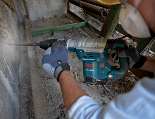 Man using Bosch 11321EVS Boschhammer, drilling into a concrete wall.