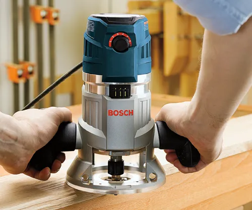 Person holding a Bosch router with the brand name visible.