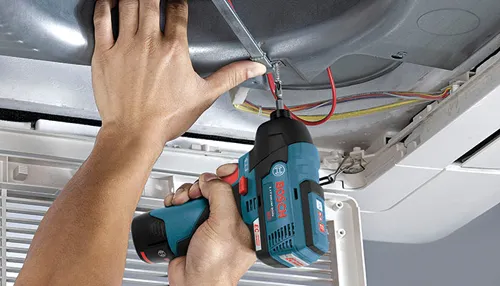 Person using Bosch Lithium Ion EC impact driver to secure wiring.