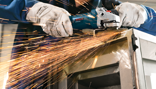 Bosch GWS8-45 angle grinder grinding metal, generating sparks.