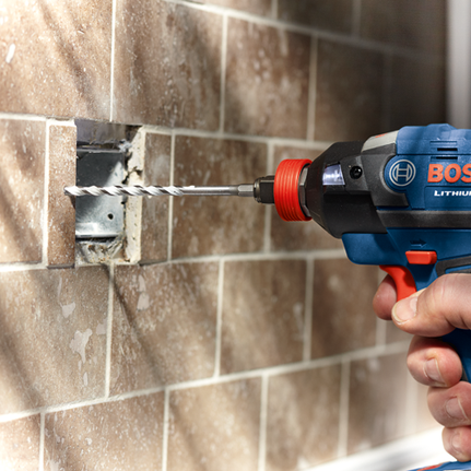 Bosch Lithium drill drilling into a tile wall.