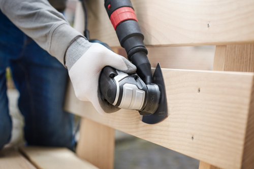 Bosch oscillating multi-tool cutting a piece of wood.