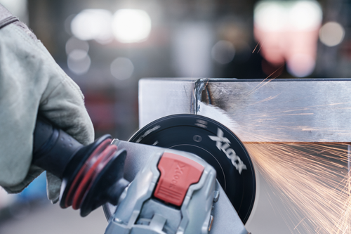 X-LOCK grinder cutting metal, creating sparks.