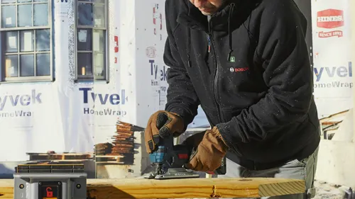 Person using a Bosch jigsaw to cut wood; "HINES SINCE 1892" and "Tyvek HomeWrap" visible in background.