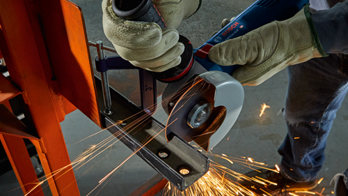 Bosch GWS10-450 angle grinder cutting metal, with sparks flying.