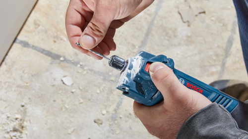 Man holding a drill with "BOSCH" visible on it.