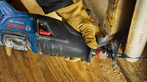 Bosch GSA18V-110 reciprocating saw cutting a white pipe, held by a gloved hand.