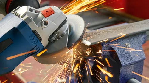 Metal being cut with an angle grinder, producing sparks.