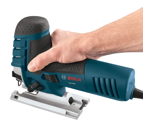 Bosch JS470EB jigsaw being held by a light-skinned hand.