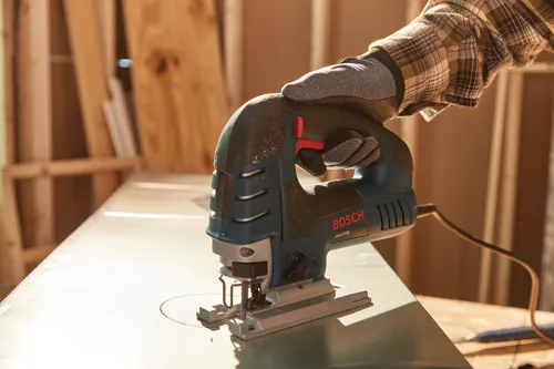 Man using the Bosch corded jig saw to cut a circle in metal.