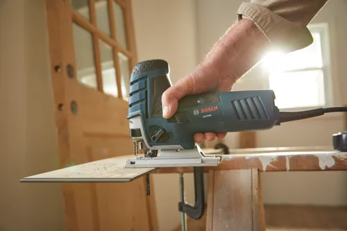 Bosch JS470EB jigsaw being used to cut a piece of wood.